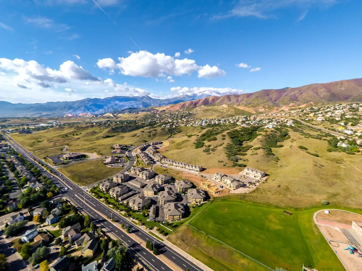 Aerial view of a neighborhood of houses below the mountains