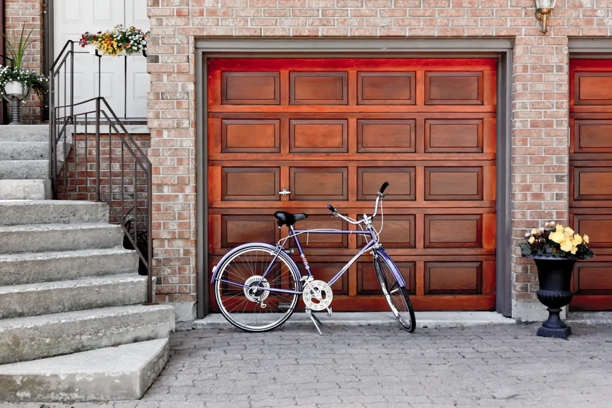 A red wood garage door next to a bicycle