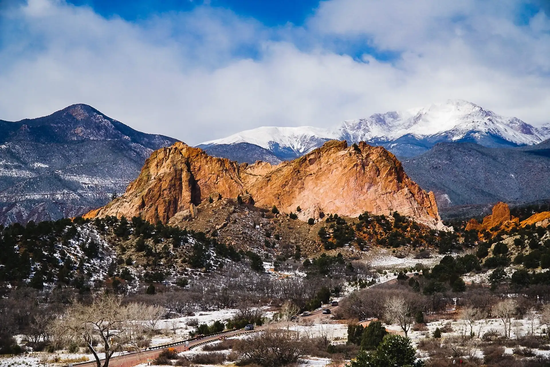 Red sandstone formations in front of a snow-covered peak on the Front Range