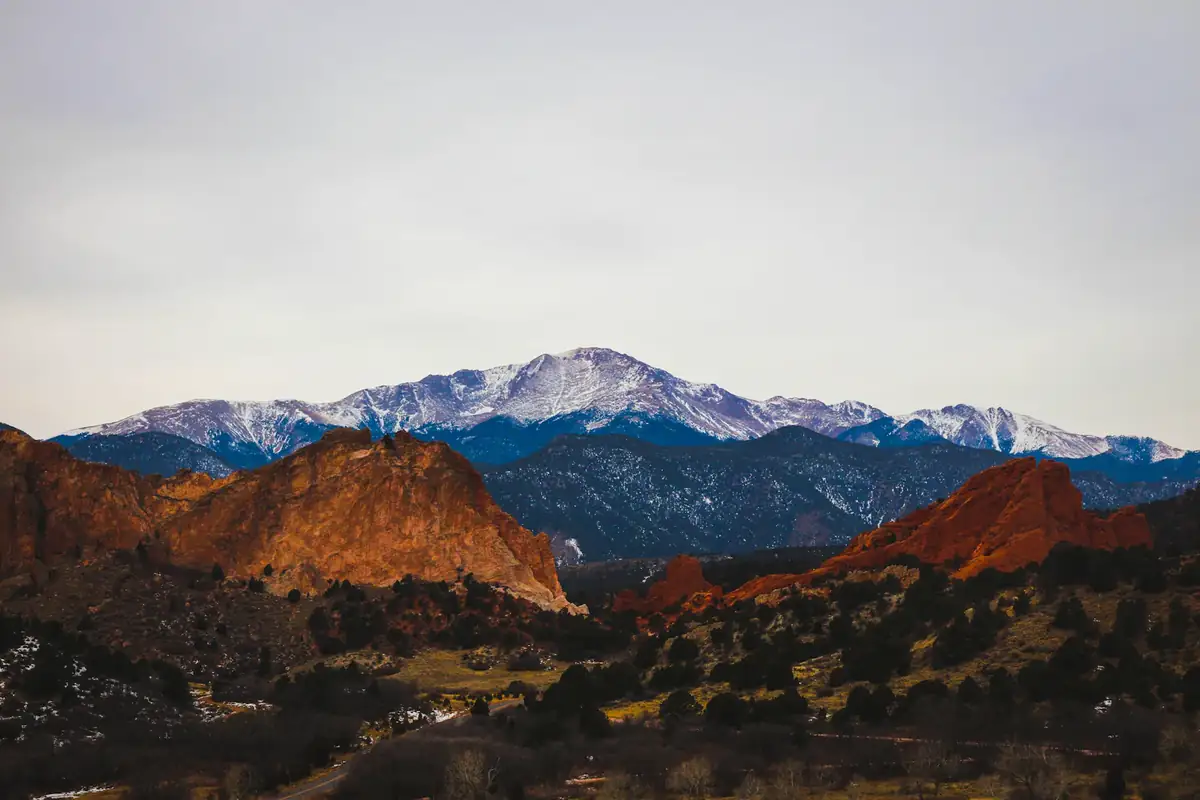 Snow-capped mountain above brown foothills